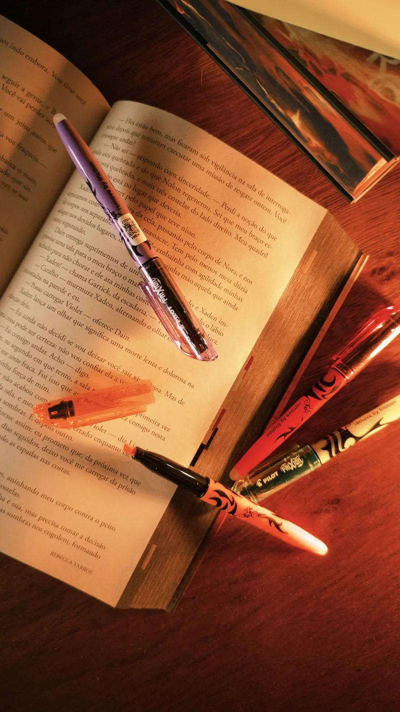 Livro aberto com marca-textos coloridos ao lado